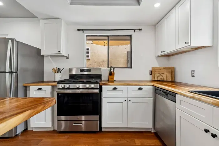 Open kitchen with upgraded range and cabinets.