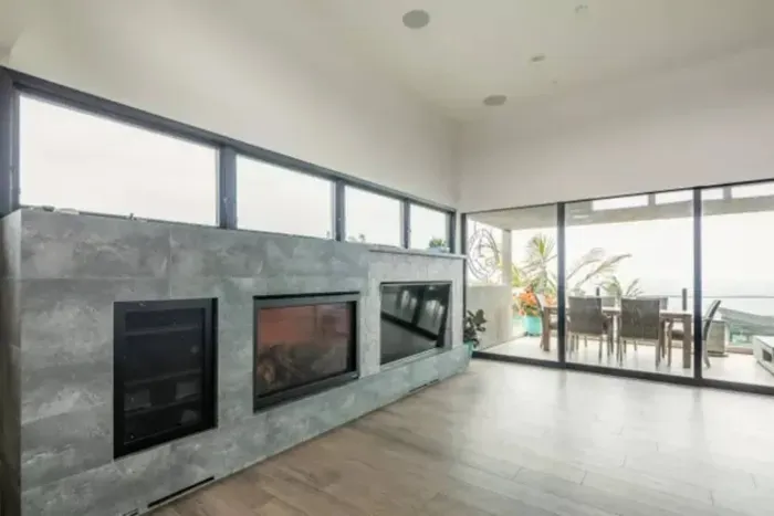 Enjoy beach views from the spacious living room with a scenic balcony and cozy fireplace.