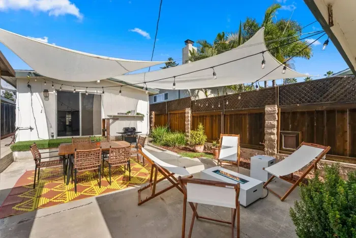 Outdoor lounge beneath canvas sails and string lights