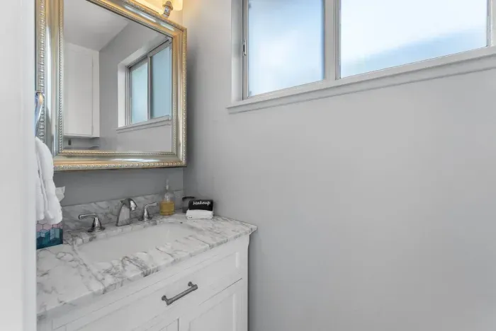 Morning light catches marble vanity and mirror