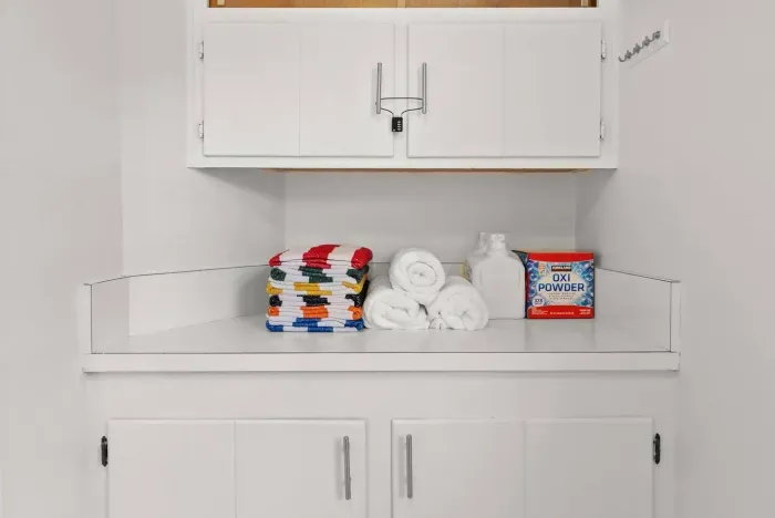 Towels folded by the laundry shelf, ready for use