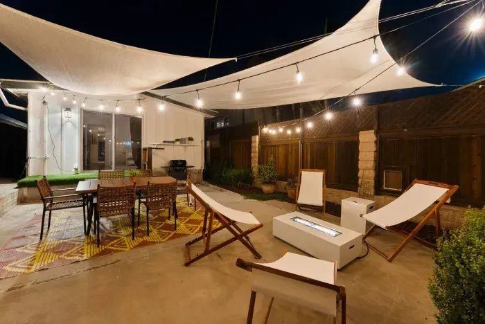 Lantern-lit patio with fire pit and sail shades