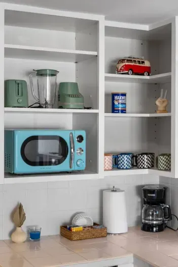 Open shelving with mint appliances and playful mugs