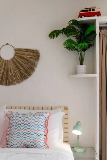 Natural fiber wall decor and palm plant complete the vibe