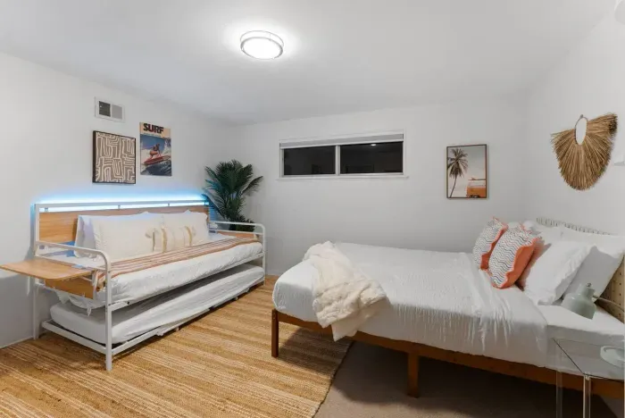 Twin beds framed by surf art and leafy greens