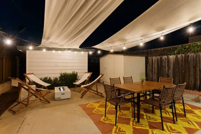 String lights glow beneath striped shade sails