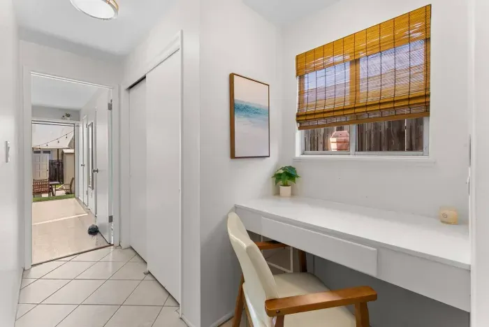 Bright hallway desk framed by woven blinds