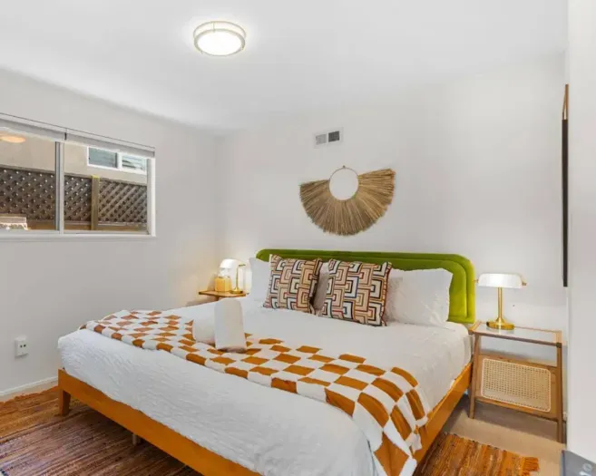 Sunlit bedroom with geometric linens and golden accents