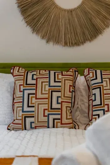 Geometric pillow and lime headboard pop against white