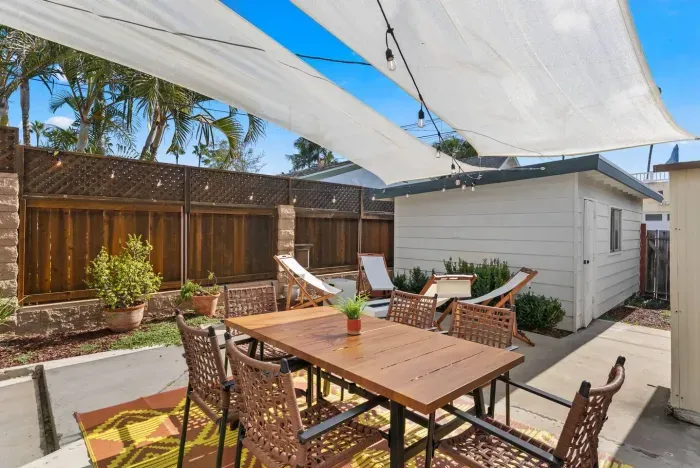 Daylight patio framed by palms and white canvas sails