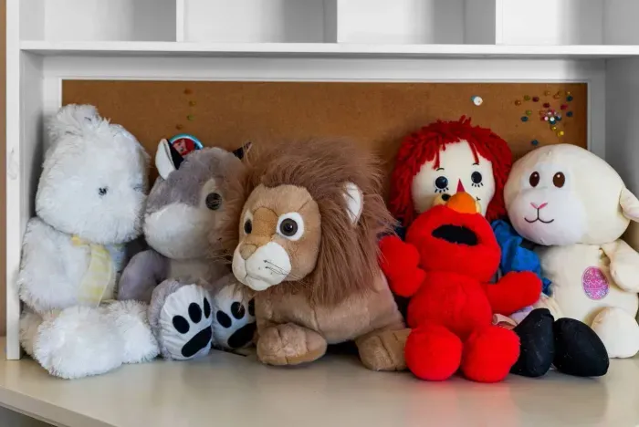 Plush lion and Elmo rest on a nursery shelf waiting for playtime