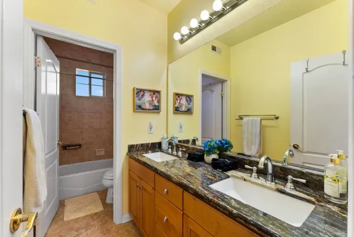 Double-sink vanity glows under warm lights and polished granite