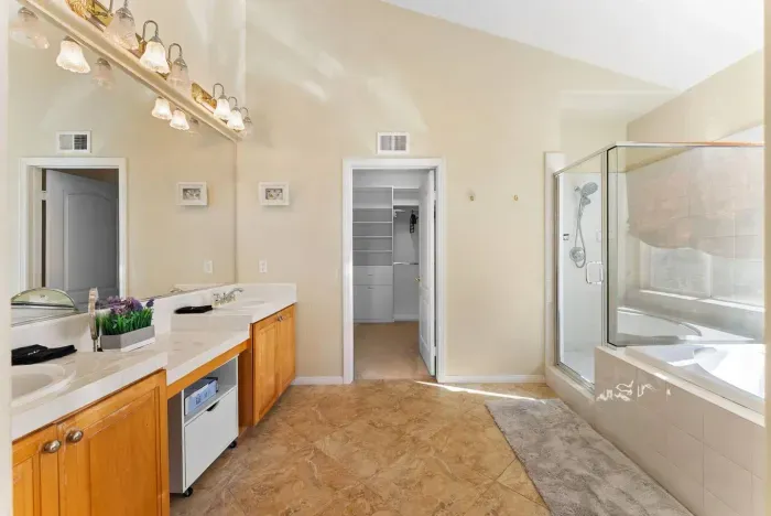 Master bath with twin vanities and glass-enclosed shower