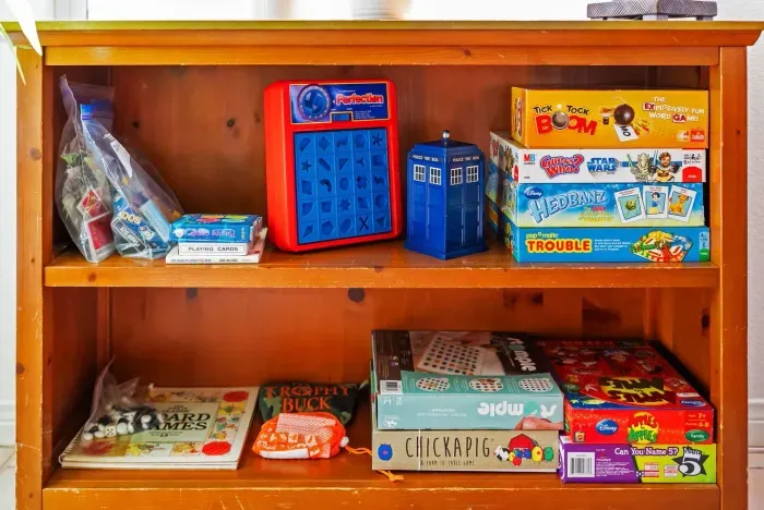 Board games stacked on wooden shelves for family nights
