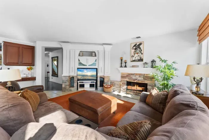 Leather sectional faces stone fireplace and TV nook