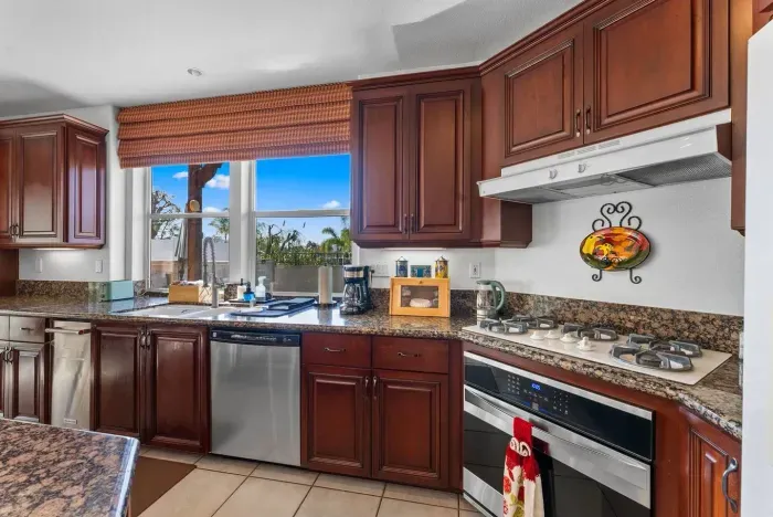Granite island anchors the kitchen with rich wood cabinetry