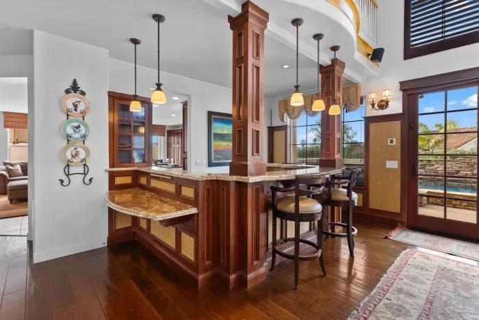 Wood pillars frame a polished bar with pendant lighting