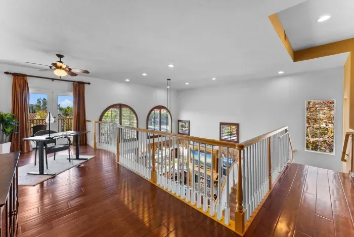 Loft hallway bathed in natural light and polished wood rails
