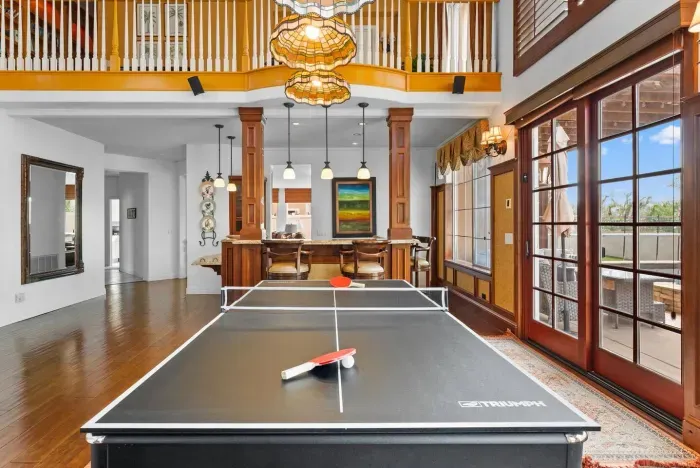 Ping-pong table set beneath high windows and chandeliers
