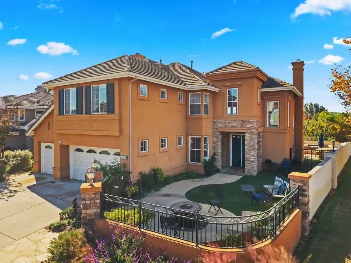 Stately front entry framed by soft light and manicured hedges