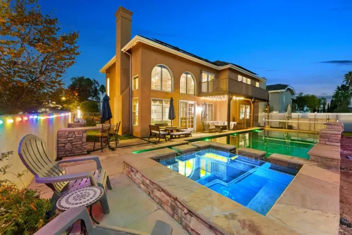 Twin pools shimmer under sunset beside the tiled deck