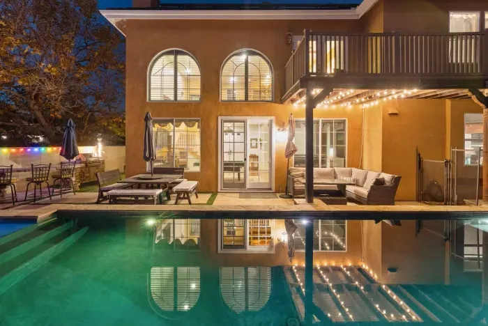 Poolside lounge reflects golden arches and string lights