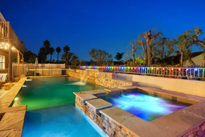 Bubbling spa glows beside the pool under twilight skies