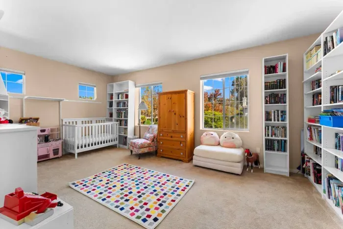 Nursery corner bathed in afternoon light through twin windows
