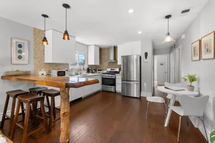 Modern open-concept kitchen with rustic wood bar, stainless steel appliances, and plenty of space to gather and cook.