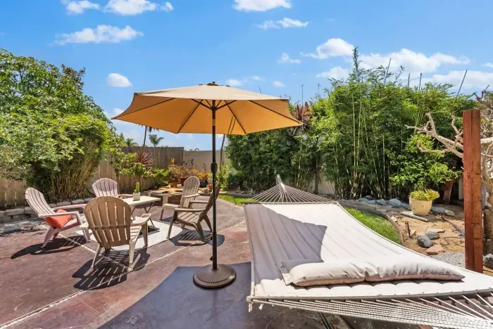 Sunny backyard escape —swing in the hammock or gather around the fire pit for the perfect coastal retreat.