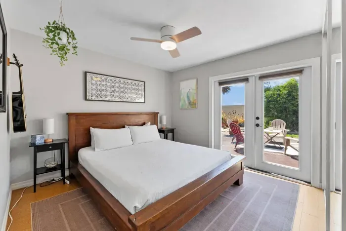 Serene king bedroom with direct patio access—wake up to sunshine and step straight into your private outdoor oasis.