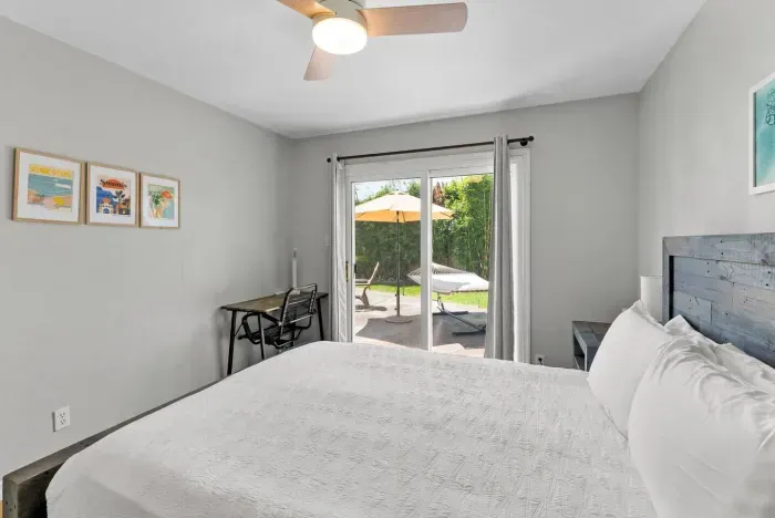 Peaceful bedroom retreat with a king bed, work desk, and sliding doors that open to the sunny patio and hammock.