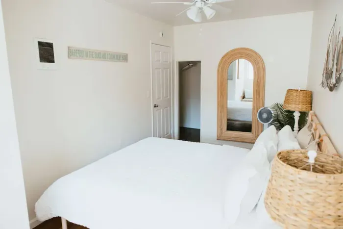 Bright bedroom with wicker lamp and serene sailboat décor.