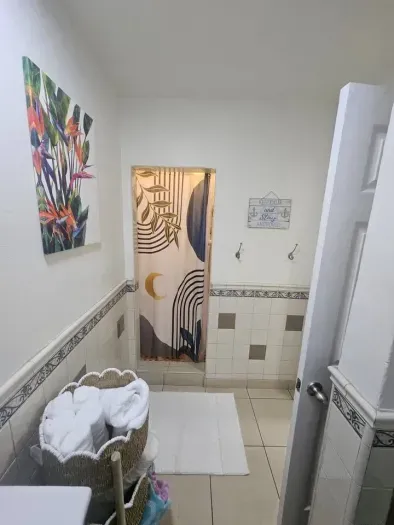 Cheerful bathroom with patterned shower curtain and decor.