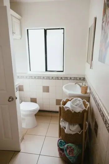 Bright bathroom with window, vanity, and warm neutral tile.
