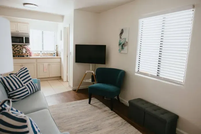 Relaxing lounge area with TV and stylish teal accent chair.