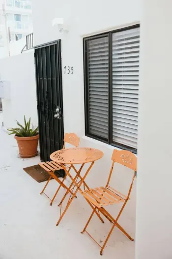 Small patio with bright orange bistro set for morning coffee.