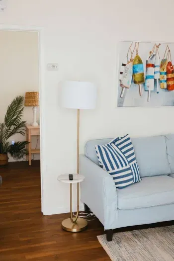 Inviting sofa with striped pillows and cheerful beachy artwork.