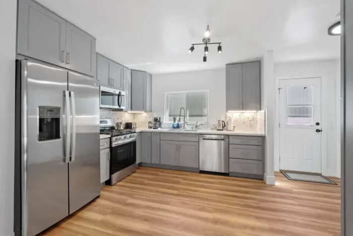 Modern kitchen with stainless steel appliances and gray cabinetry.