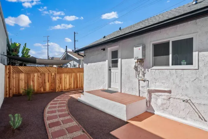 The backyard is clean and low-maintenance, with a charming walkway and fresh landscaping!