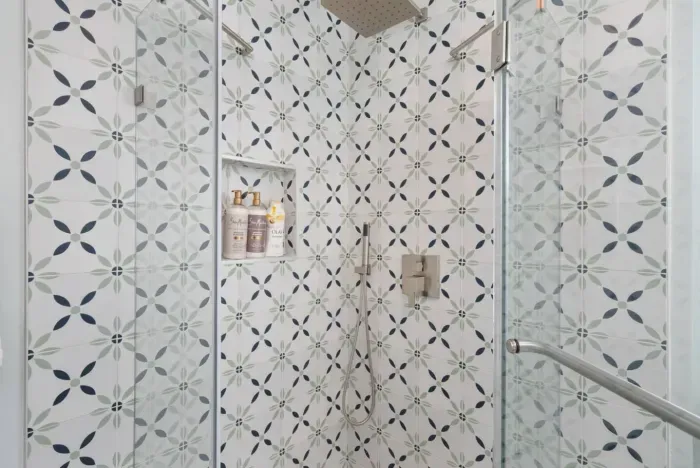 The shower's patterned tile and modern fixtures create a spa-like feel!