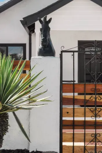 A striking black horse head statue stands guard at the entrance.