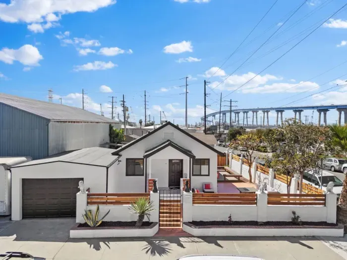 Charming home with a private patio, small garage, and an industrial backdrop near Logan Ave.