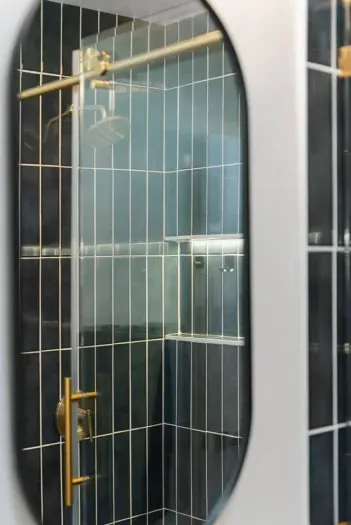 Elegant shower space with bold dark tiles and gold accents