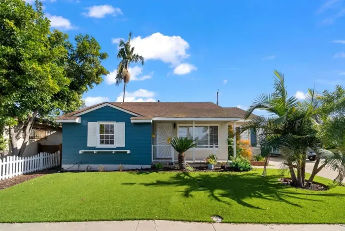 A charming coastal-inspired home with lush greenery and a welcoming front porch! 