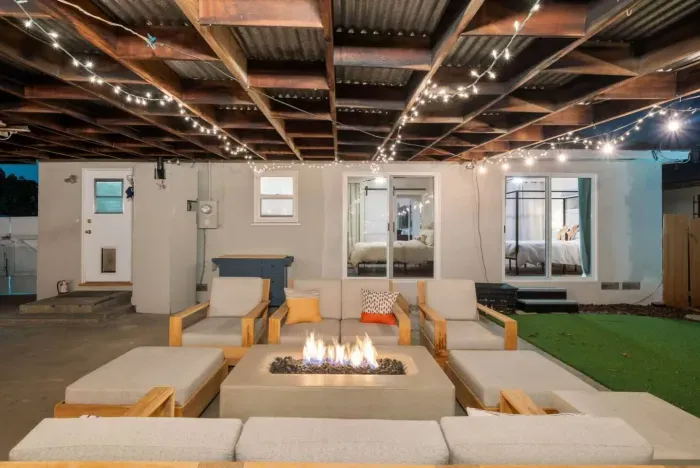The string lights, warm firepit, and cozy seating make this backyard a dreamy nighttime retreat! ✨
