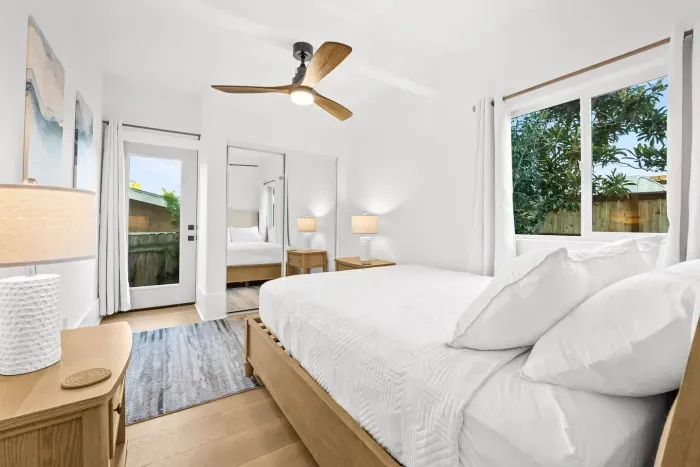 Spacious bedroom with large windows and calming decor.