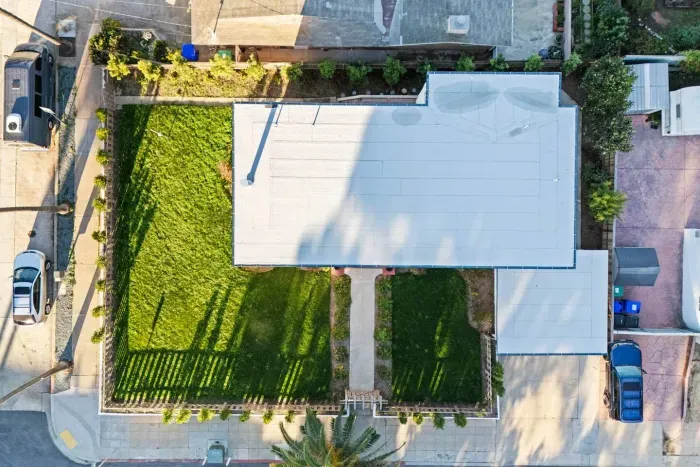 Overhead view of the home’s roof and green backyard.