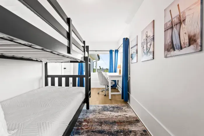 Bunk room with workspace and cozy layout.