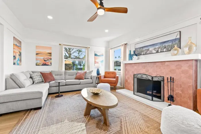 Bright living space with sectional seating and a fireplace.